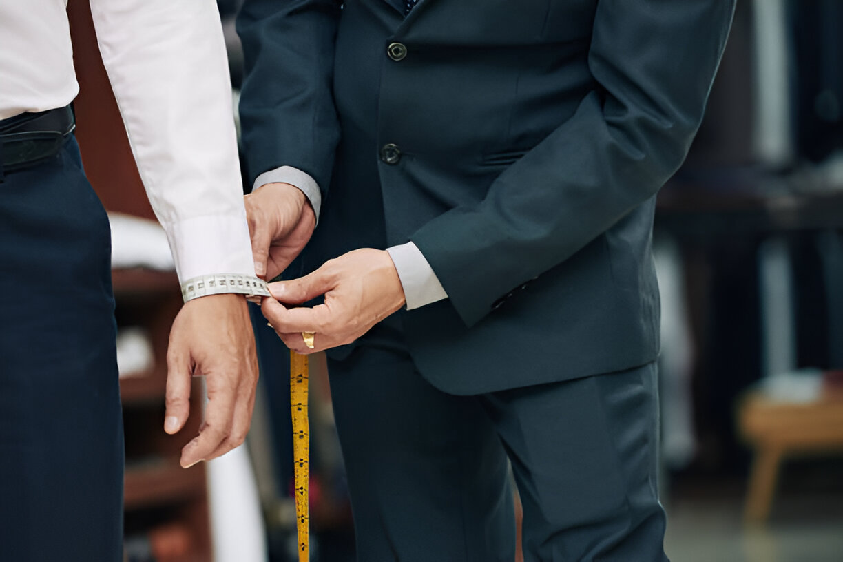 Expert suit tailor in the UAE taking custom suit mesures for a client